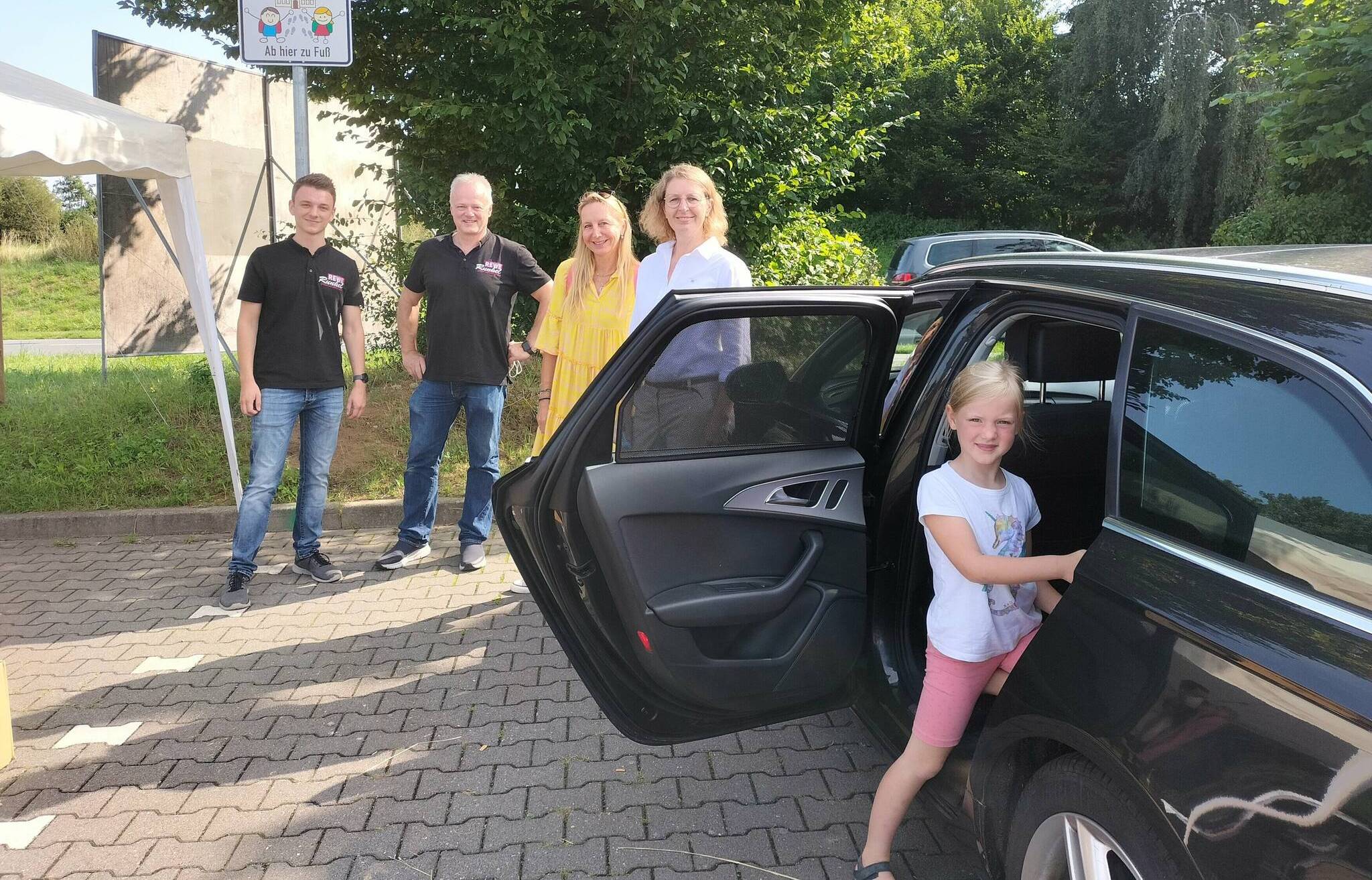   Bürgermeisterin Sandra Pietschmann, Schulleiterin Anja Schlösser-Schnelting (2.v.r.), Frank Runkel (l.) und Sohn Jan haben die neue Elternhaltestelle für die Astrid-Lindgren-Schule auf dem REWE-Parkplatz am Steinesweg offiziell eingeweiht. Dort kann Marie sicher aus dem Auto steigen. 