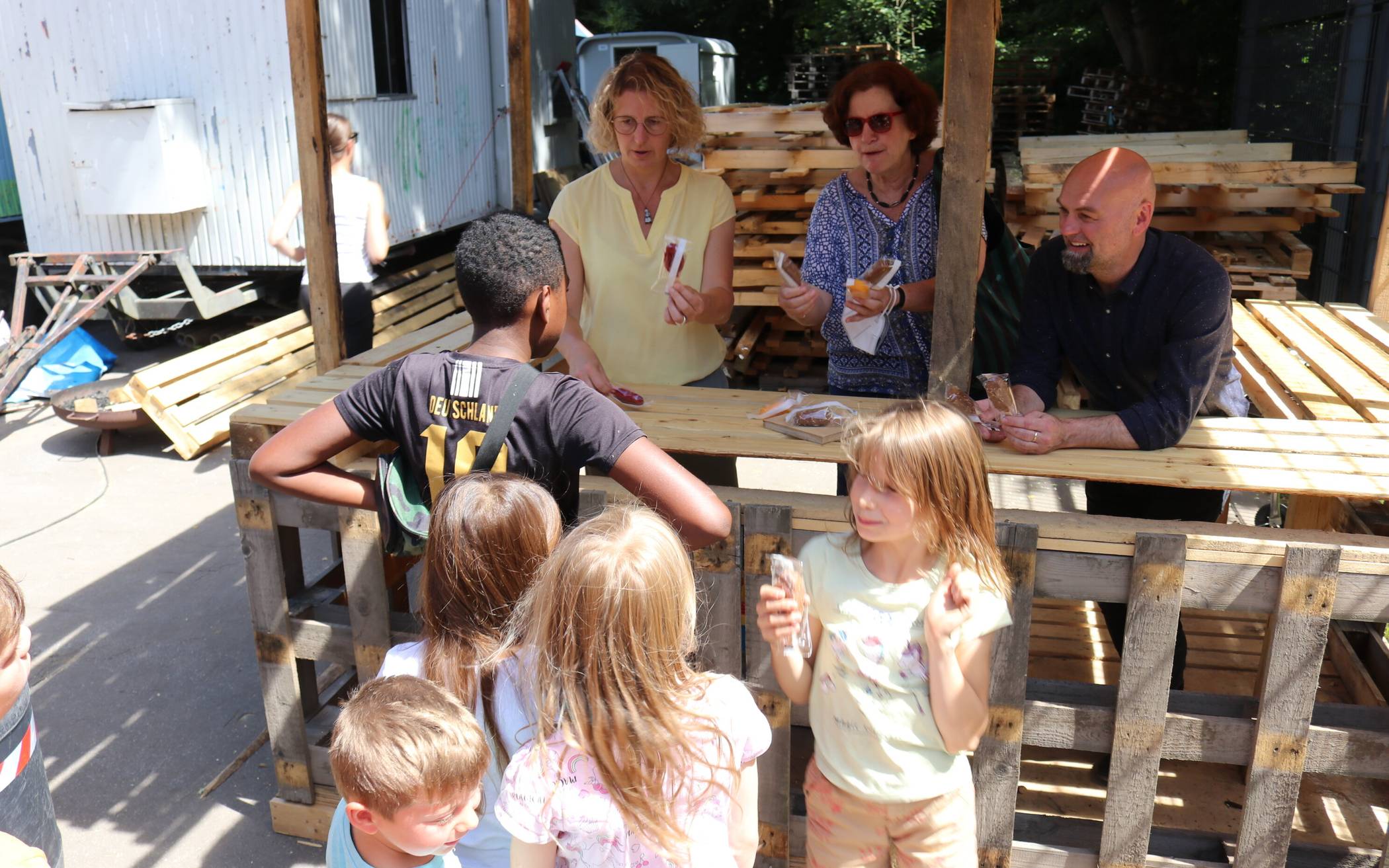  Bürgermeisterin Sandra Pietschmann, Silvia Böhm, stellvertretenden Vorsitzende des Jugendhilfeausschusses, und Jugendamtsleiter Stephan Paas verteilen Eis an die Kinder. 