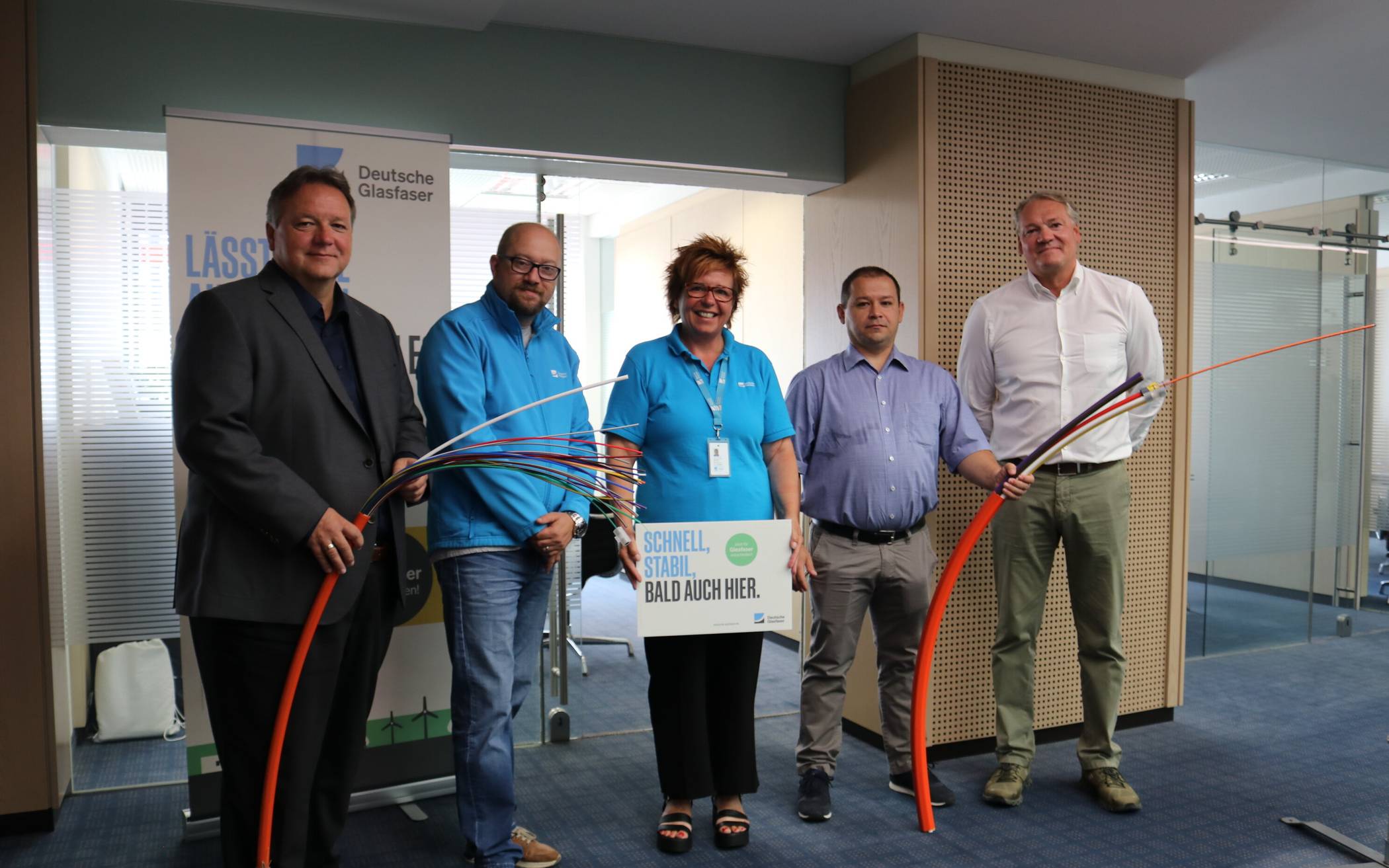  Thomas Döring, Filialdirektor der Kreissparkasse Düsseldorf, Markus Reichelt, Petra Blumenhofen und Stefan-Dan Gulutanu (Deutsche Glasfaser) sowie Mettmanns Wirtschaftsförderer Stephan Reichstein (v. l.) vor dem Büro in der Kreissparkasse am Jubiläumsplatz. 