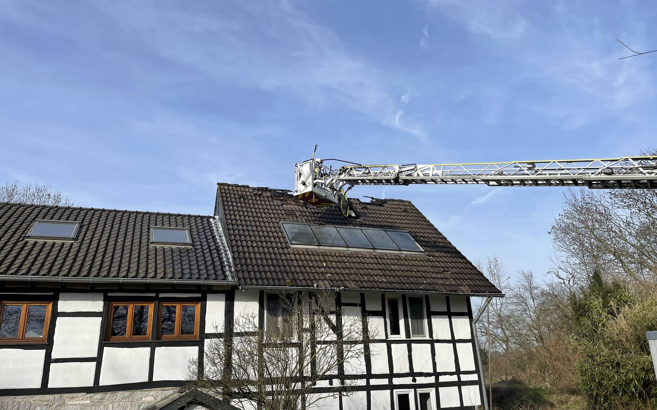 Einsatz der Drehleiter zum Abtragen der Dachhaut. 