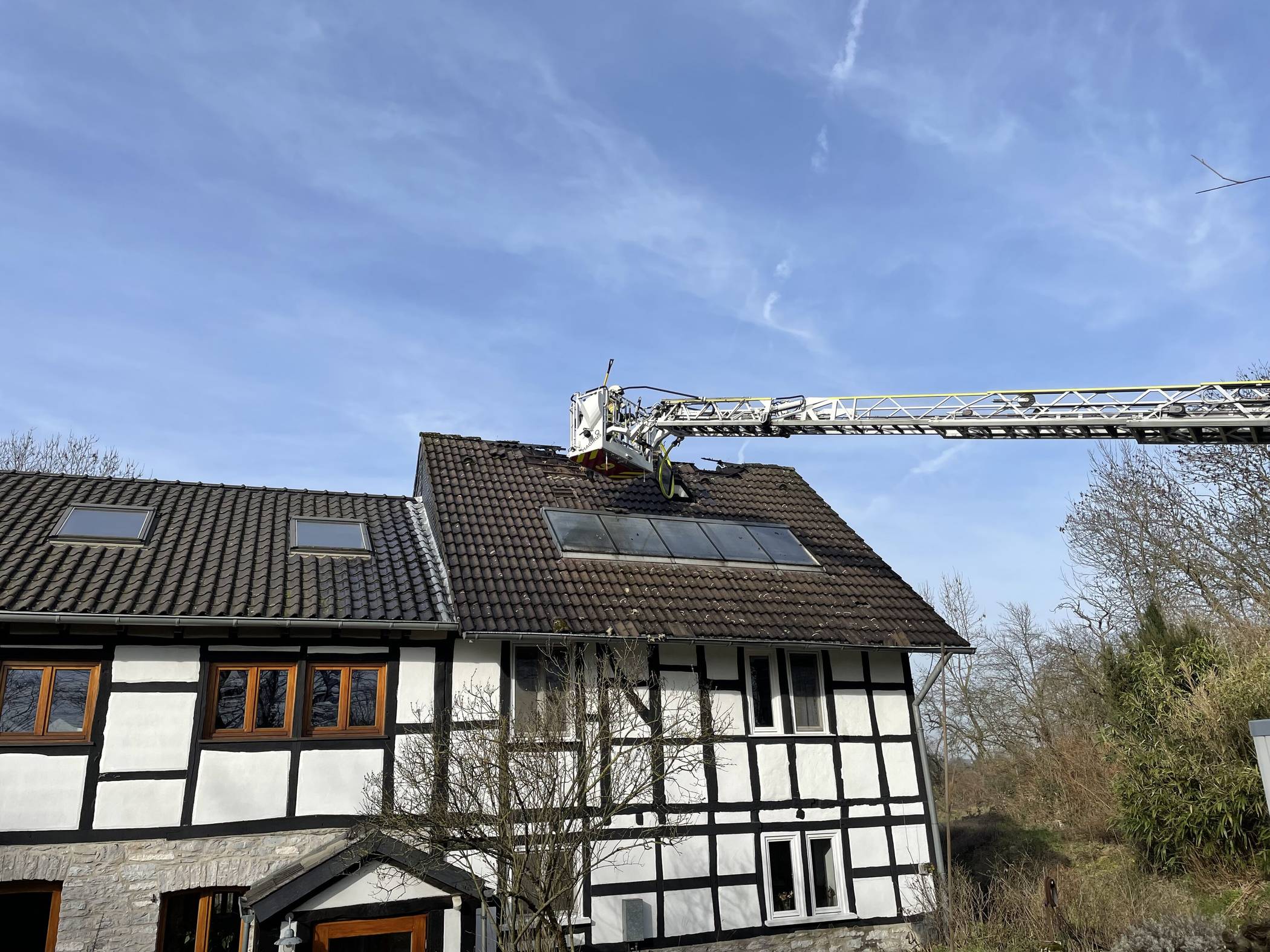 Einsatz der Drehleiter zum Abtragen der Dachhaut. 