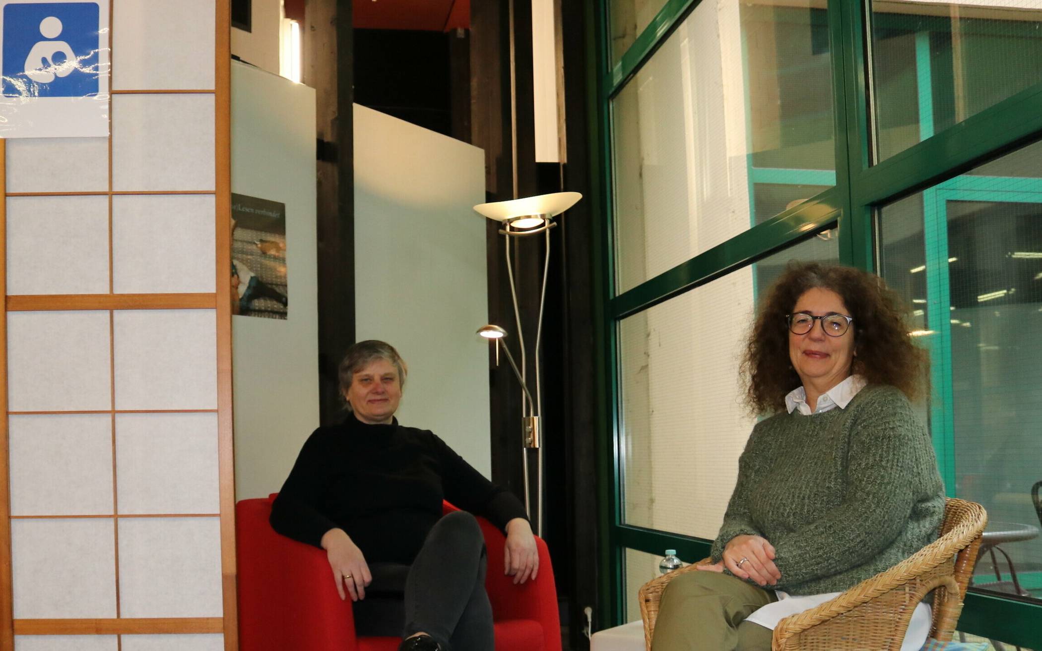 Bibliotheksleiterin Ursula Leifeld (l.) und Jugendhilfeplanerin Karen Holle in dem Bereich der Bibliothek, in dem Mütter ihre Babys in Ruhe stillen können. 