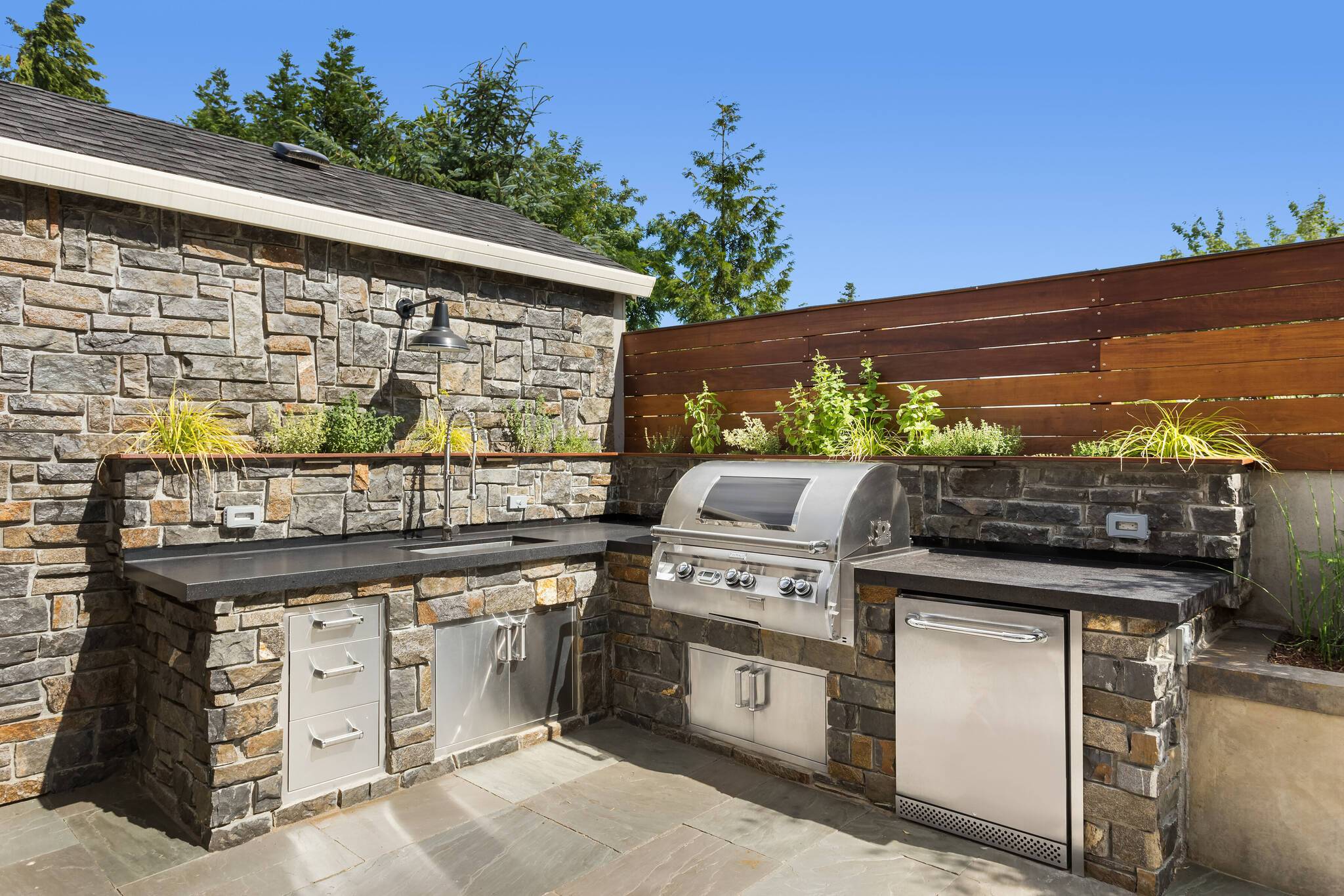  Outdoor-Küchen laufen mittlerweile dem einfachen Holz-Klapp-Grill den Rang ab. Ganze Küchenzeilen finden sich mittlerweile im Außenbereich wieder. Modulare Systeme und langlebige Materialien machen es möglich.  