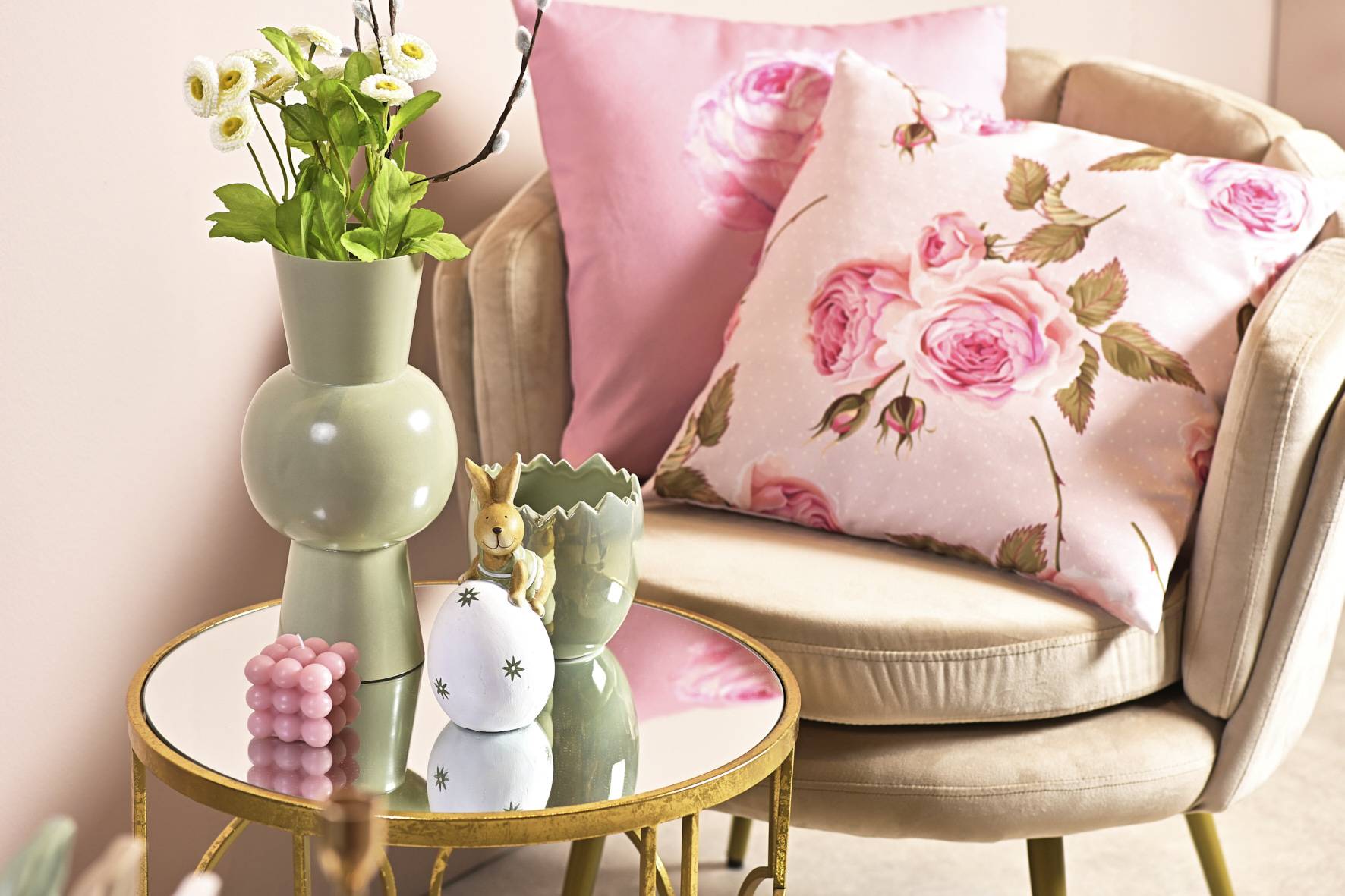 Zu frühlingshaften Kissen in Rosa passen Osteraccessoires in Pastellfarben.