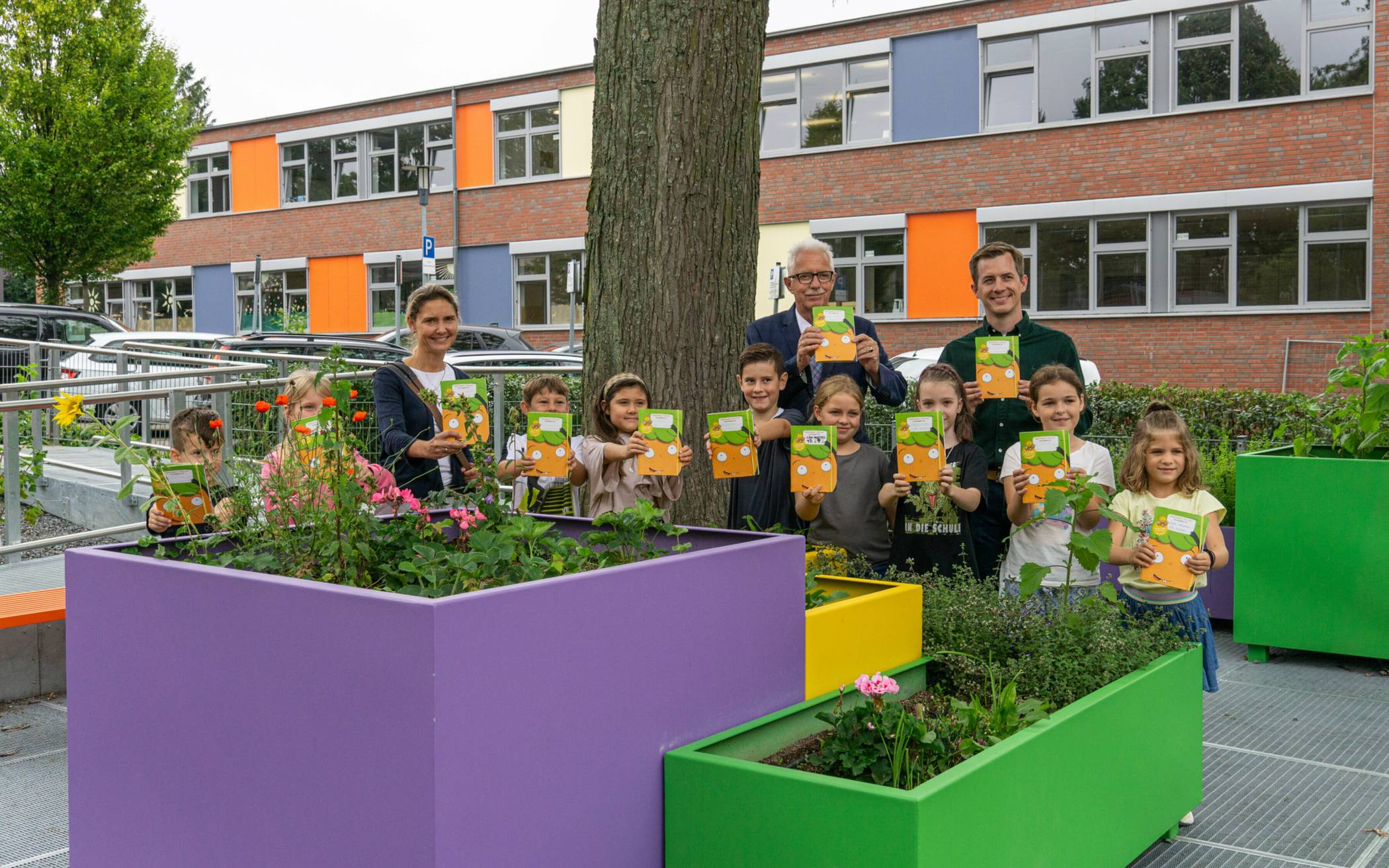 Landrat Thomas Hendele überreicht im Beisein von Bürgermeisterin Dr. Bettina Warnecke und Schulleiter Michael Jans das Möhrchenheft an die Schüler der Grundschule Mittelhaan.