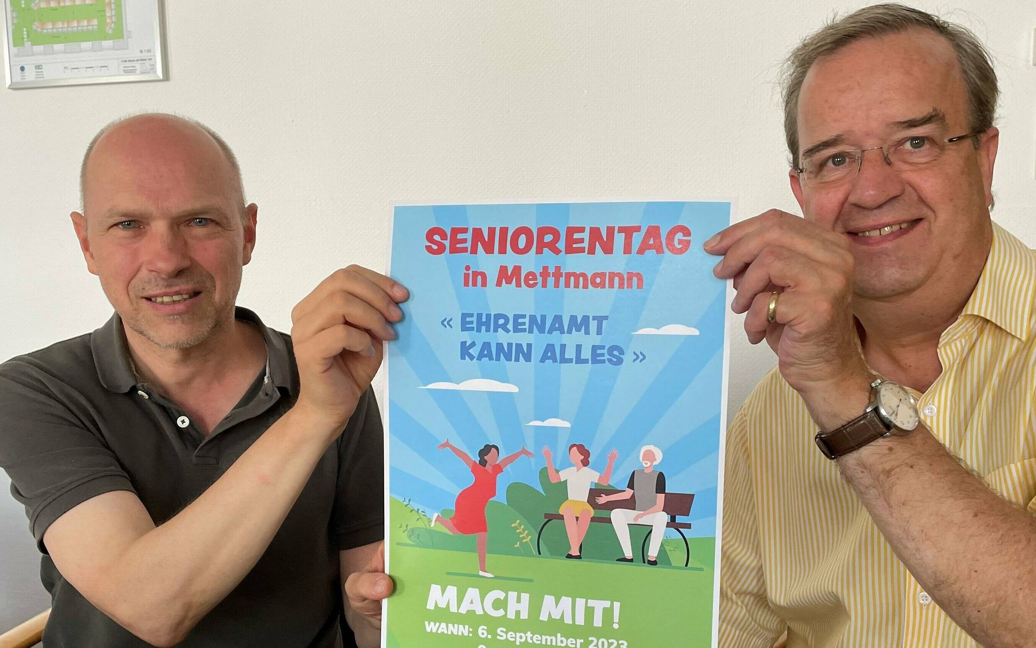  Stefan Wigge (r.) und Oliver Pahl mit dem Plakat des Seniorentages am 6. September. Foto: Kreisstadt Mettmann 