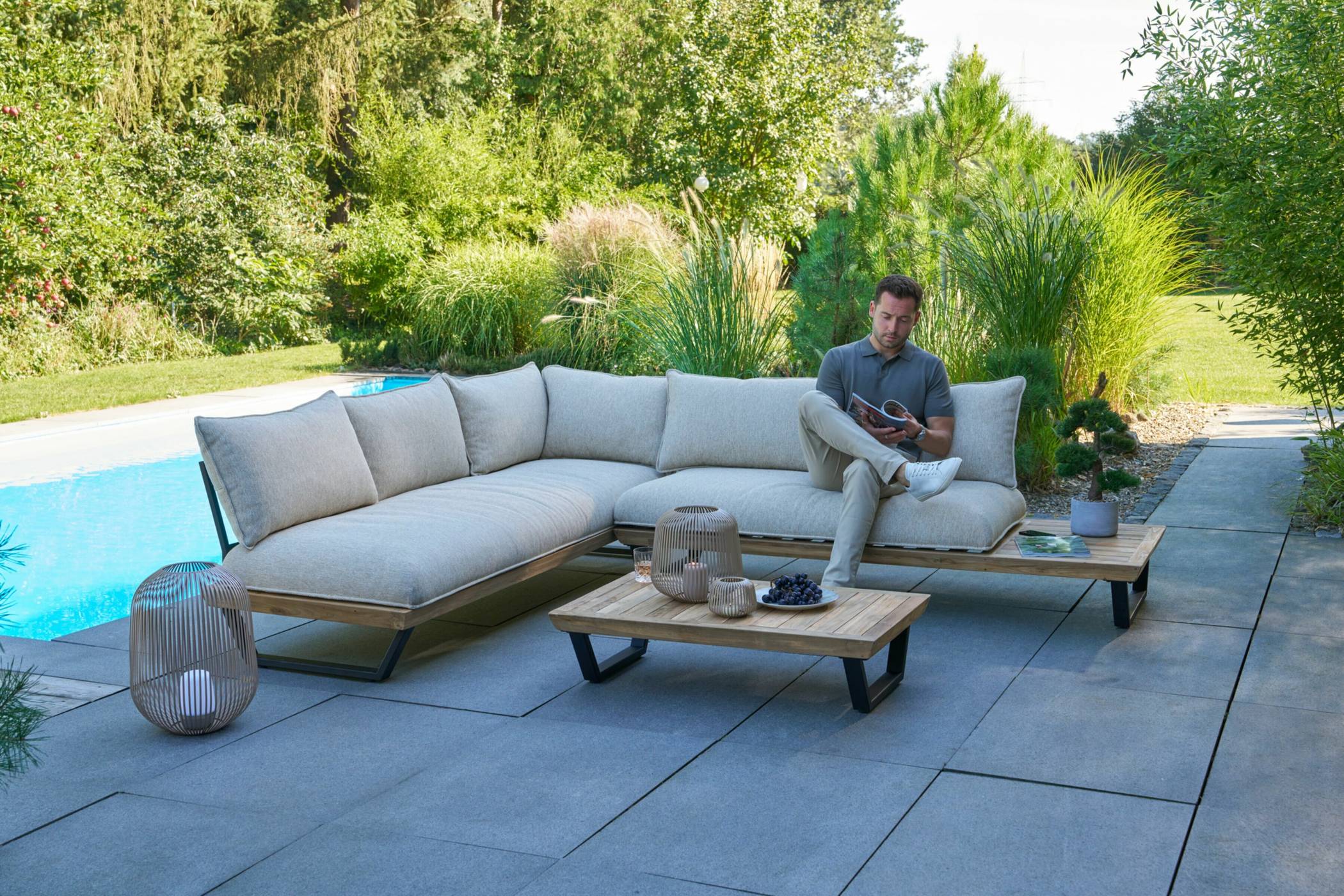  Für eine Wohlfühloase im Garten: das Sofaset „Osaka“ in Off-White besteht aus bequemen Polstern und recyceltem Teakholz. 