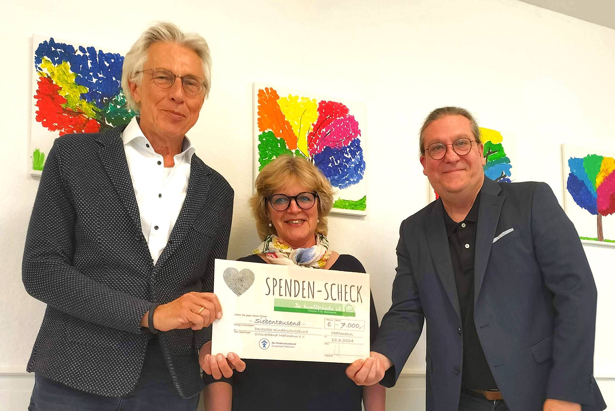  Der 1. Vorsitzende des Kinderschutzbundes, Dr. Jürgen Winkelmann und Geschäftsführerin Angela Mäder nehmen den symbolischen Scheck vom 1. Vorsitzenden der Knallfrösche, Ingo Grenzstein, entgegen. 