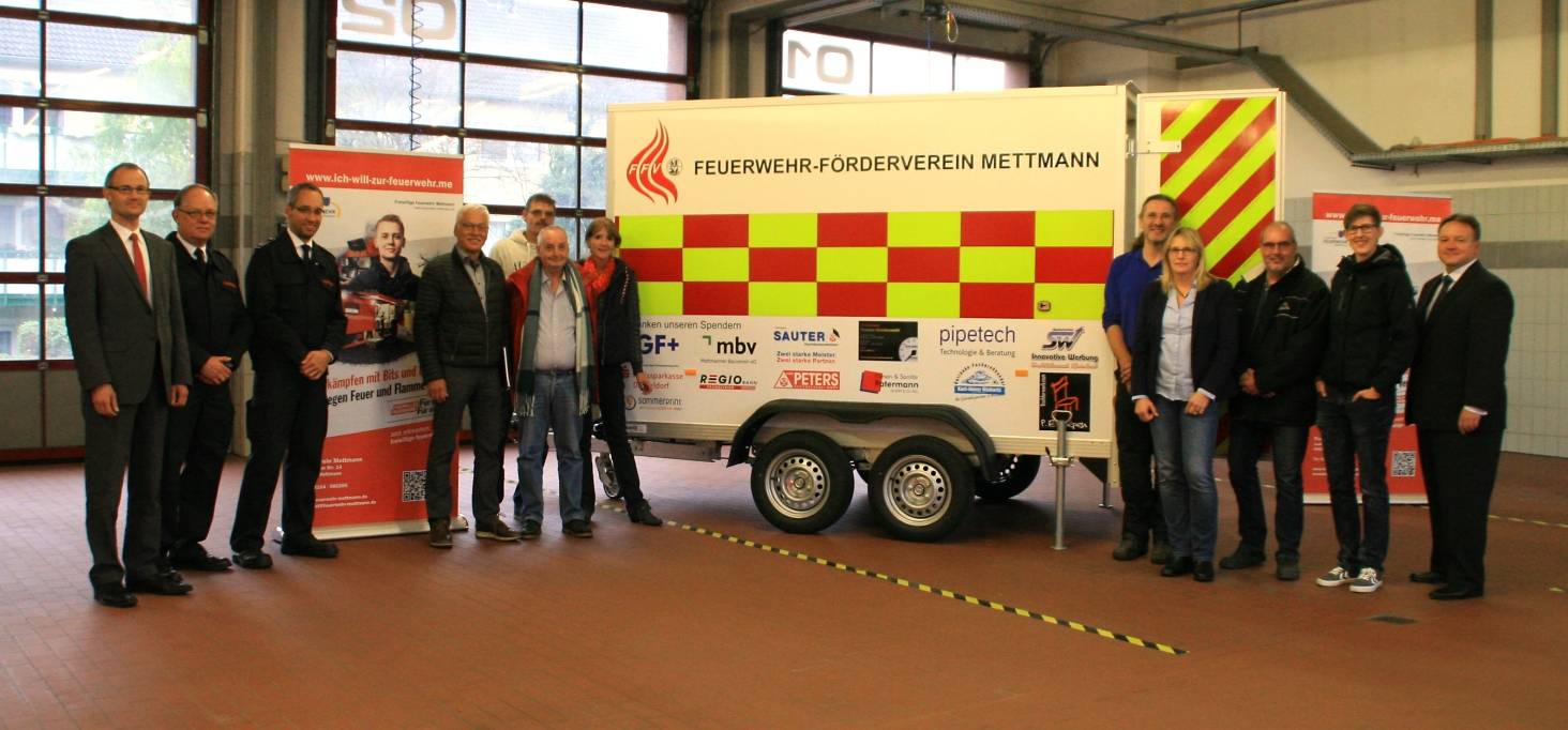  Benedikt Lamerz, Rainer Stauff und Marco Zerweiss zusammen mit eingeladenen Spendern vor dem neuen Anhänger der Jugendfeuerwehr. 