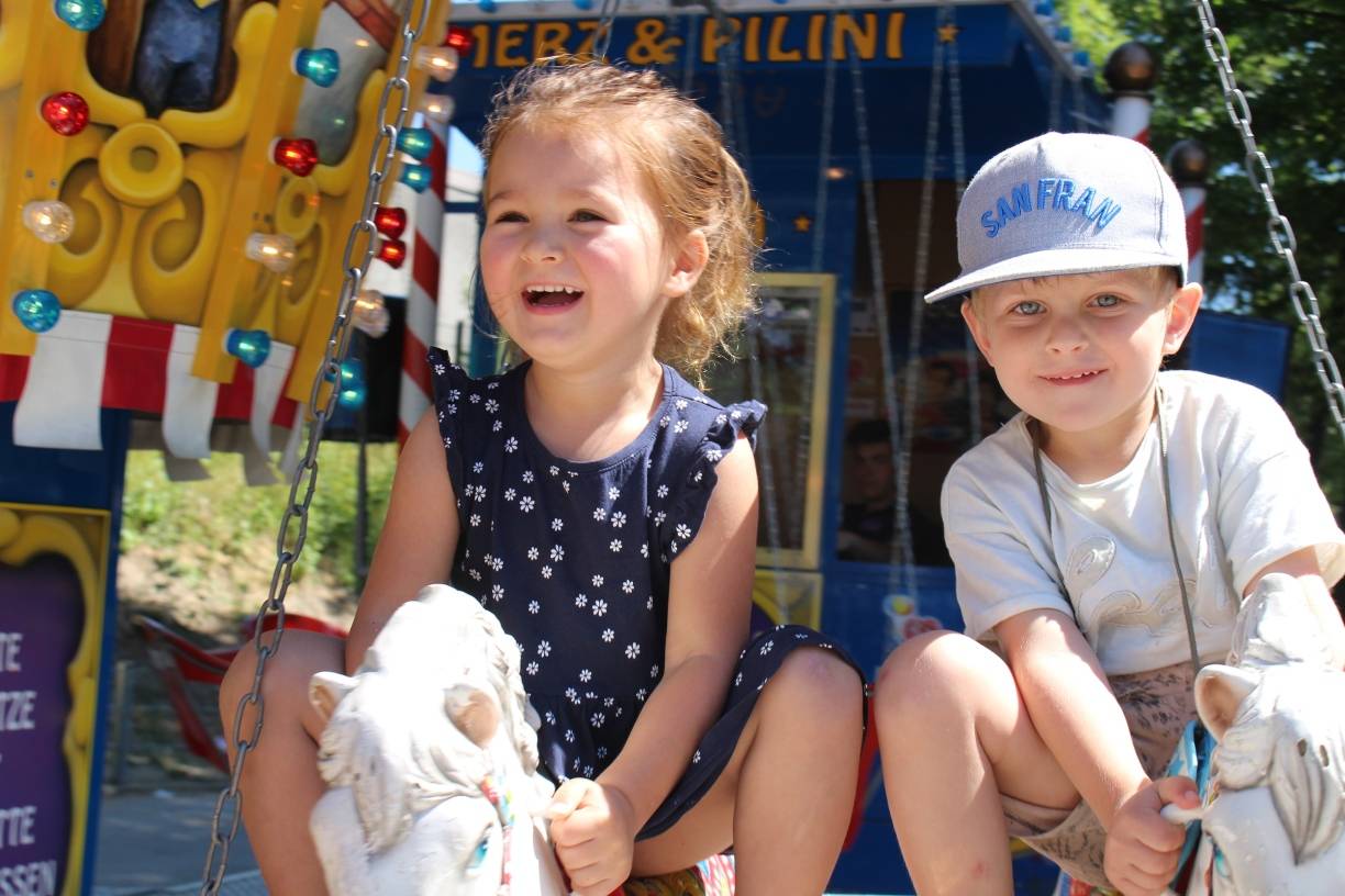 Lara und ihr bester Freund Levio sind von dem historischen Karussell auf dem Kinderfest Metzkausen ganz begeistert und fahren Runde um Runde auf den Pferden.  