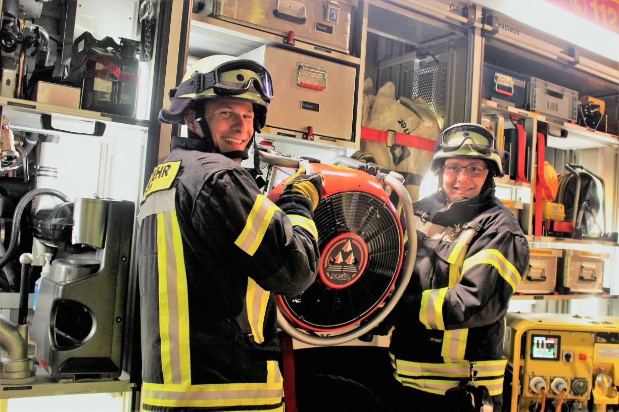  Die beiden freiwilligen Feuerwehrmänner Dennis Brauckmann und Alexander Jacobs zeigen den „Neulingen“, wie ein Löschfahrzeug der Feuerwehr aufgebaut ist.  