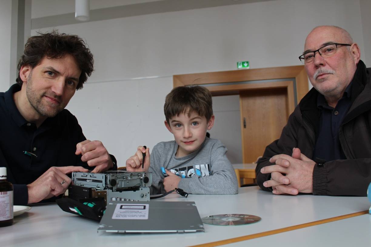  Johannes Leuer und Sohn Johannes versuchen den CD- Wechsler von Manfred Schwäbe zu reparieren. 