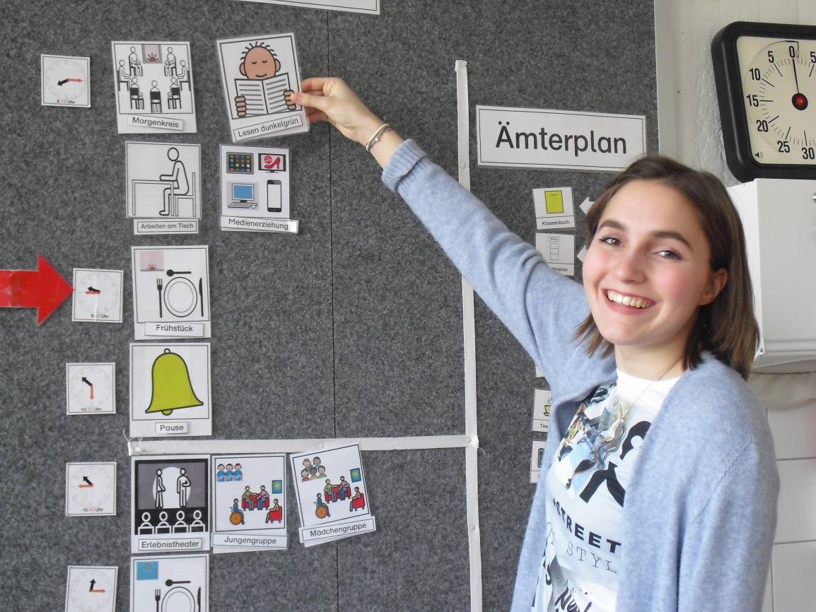  FSJ'lerin Alina bereitet den Stundenplan für den Tag vor. Für die zwölf Mädchen und Jungen in "ihrer" Mittelstufen-Klasse sind die Piktogramme eine Hilfe, um sich im Tagesablauf zu orientieren. 