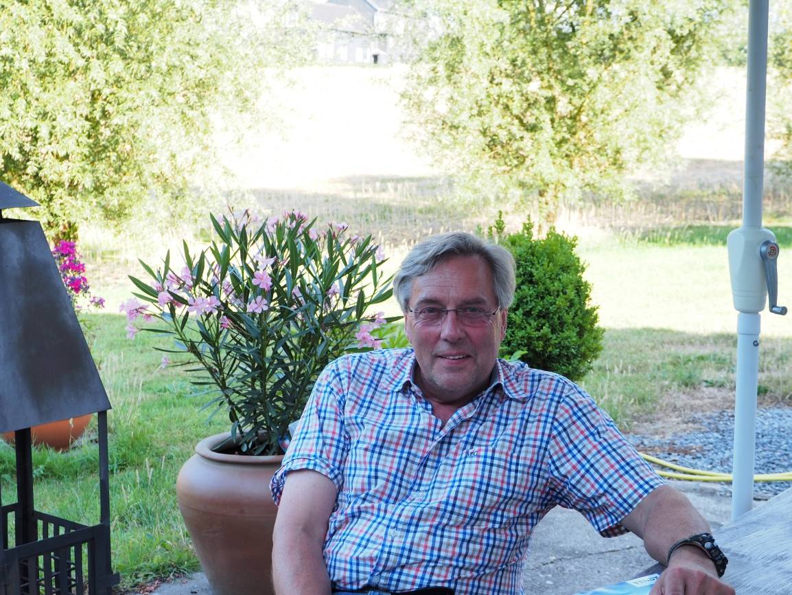  Carl Comberg auf seiner Terrasse. Im Hintergrund eines der abgeernteten Felder. 