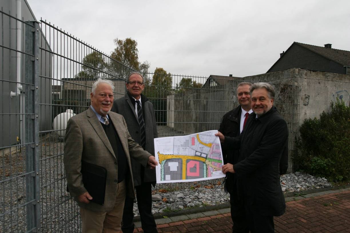  Winfried Bleckmann von der Christlich-Freikirchlichen Gemeinde, Franz Heuel, Geschäftsführer des Jobcenters, Marcus Kowalczyk, Geschäftsführer der Agentur für Arbeit Mettmann, und Bürgermeister Thomas Dinkelmann zeigen einen Plan, in dem der neue Weg schon eingezeichnet ist, der hinter ihnen herführen wird. 