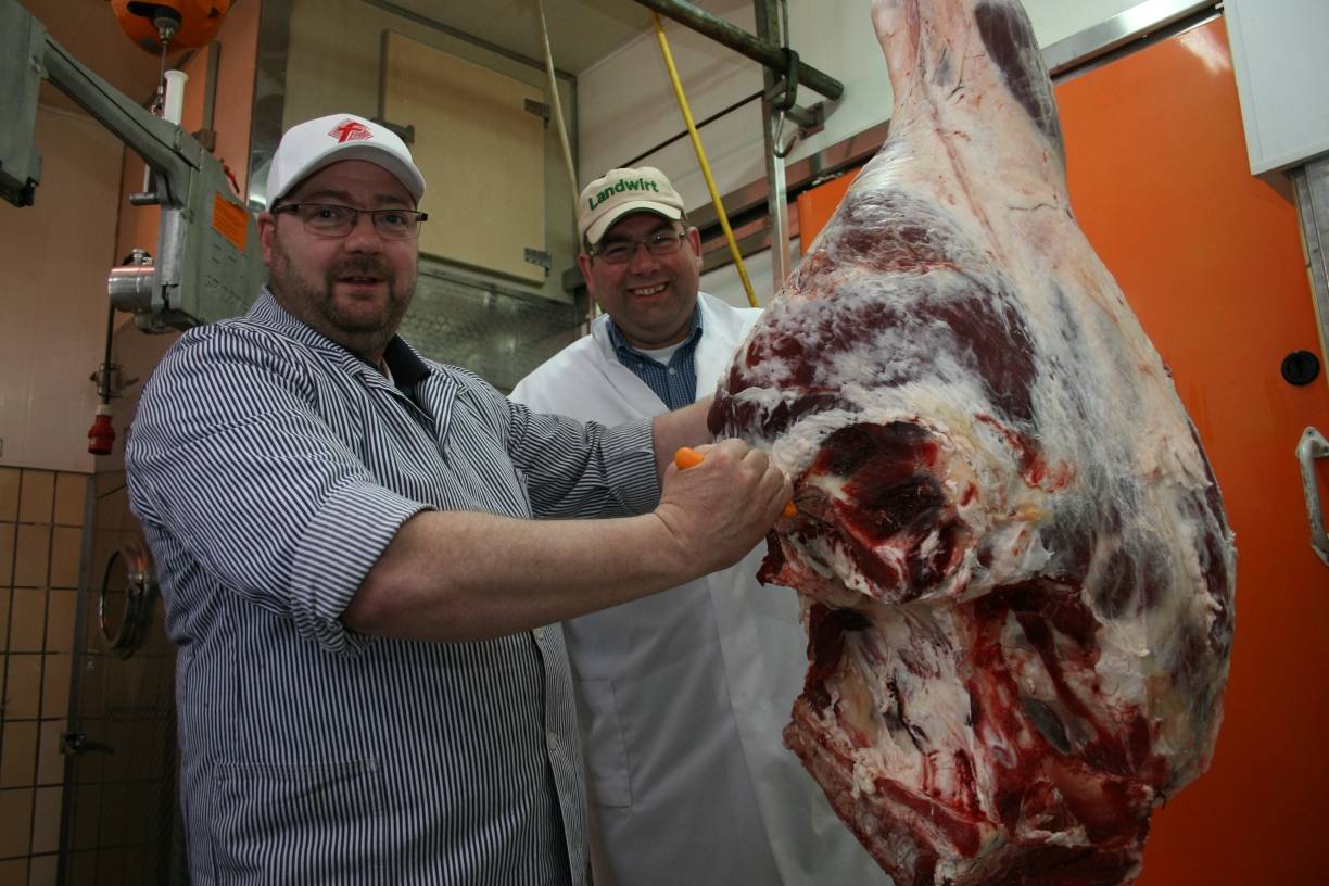  Landwirt Carsten Bröcker und Metzger Thomas Kluke an der Keule eines am Donnerstag in Metzkausen geschlachteten Jungbullen. 