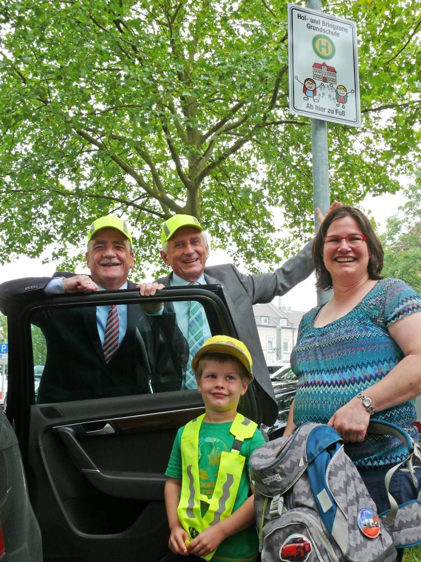  Einsatz gegen das Verkehrschaos vor Schulen (v.l.): NRW-Verkehrsminister Michael Groschek und Prof. Dr.-Ing. Jürgen Brauckmann, Präsident der Landesverkehrswacht, helfen Julian Bartsch und Mama Christine bei Ausstieg an der Hol- und Bringzone. 