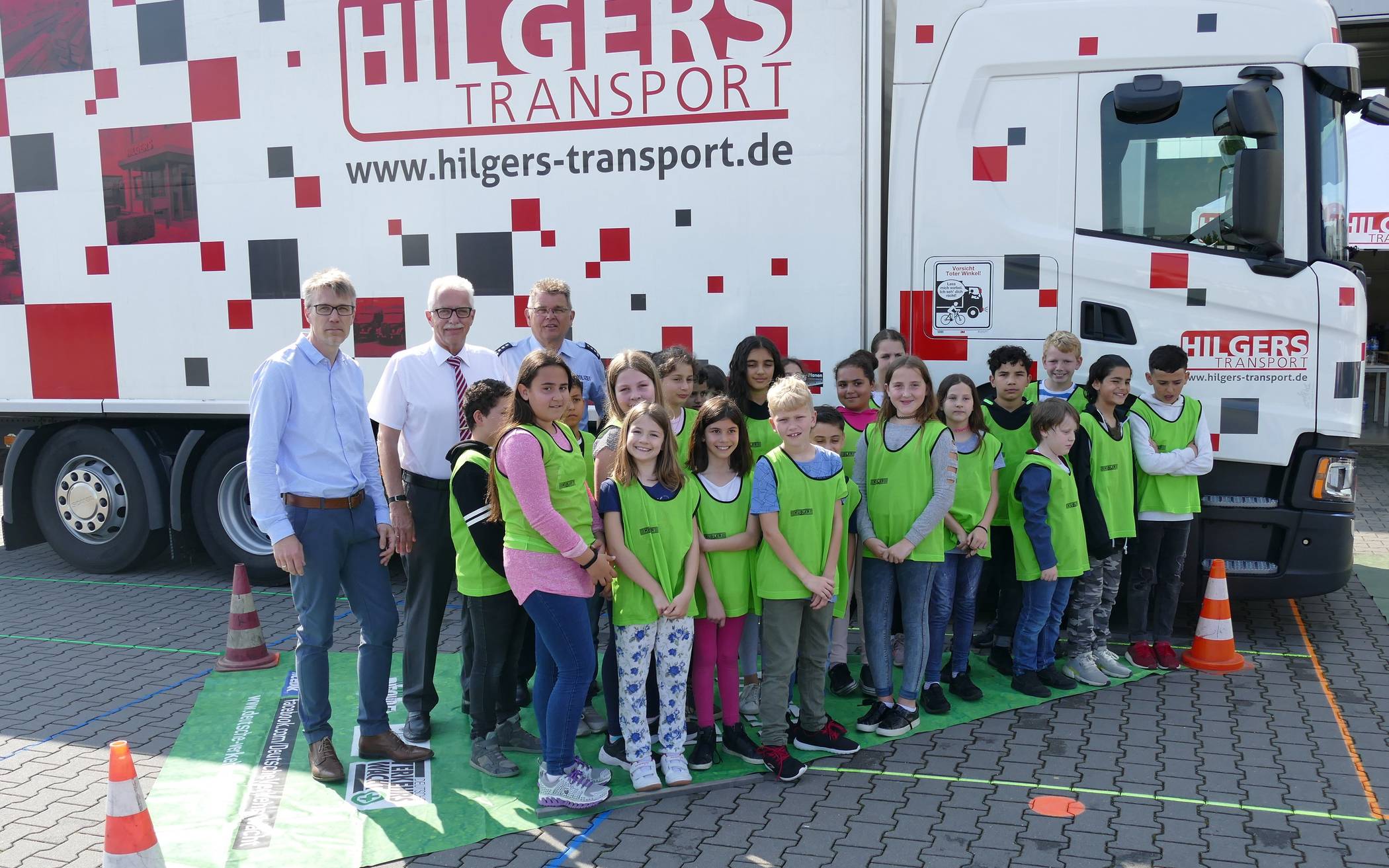  Ferdi Hilgers, Landrat Thomas Hendele, Schirmherr der Kreisverkehrswacht, Ralf Schefzig, Vorsitzender der Kreisverkehrswacht Mettmann und Direktor Verkehr bei der Kreispolizeibehörde Mettmann stehen gemeinsam mit den Monheimer Grundschülern im „toten Winkel“. 