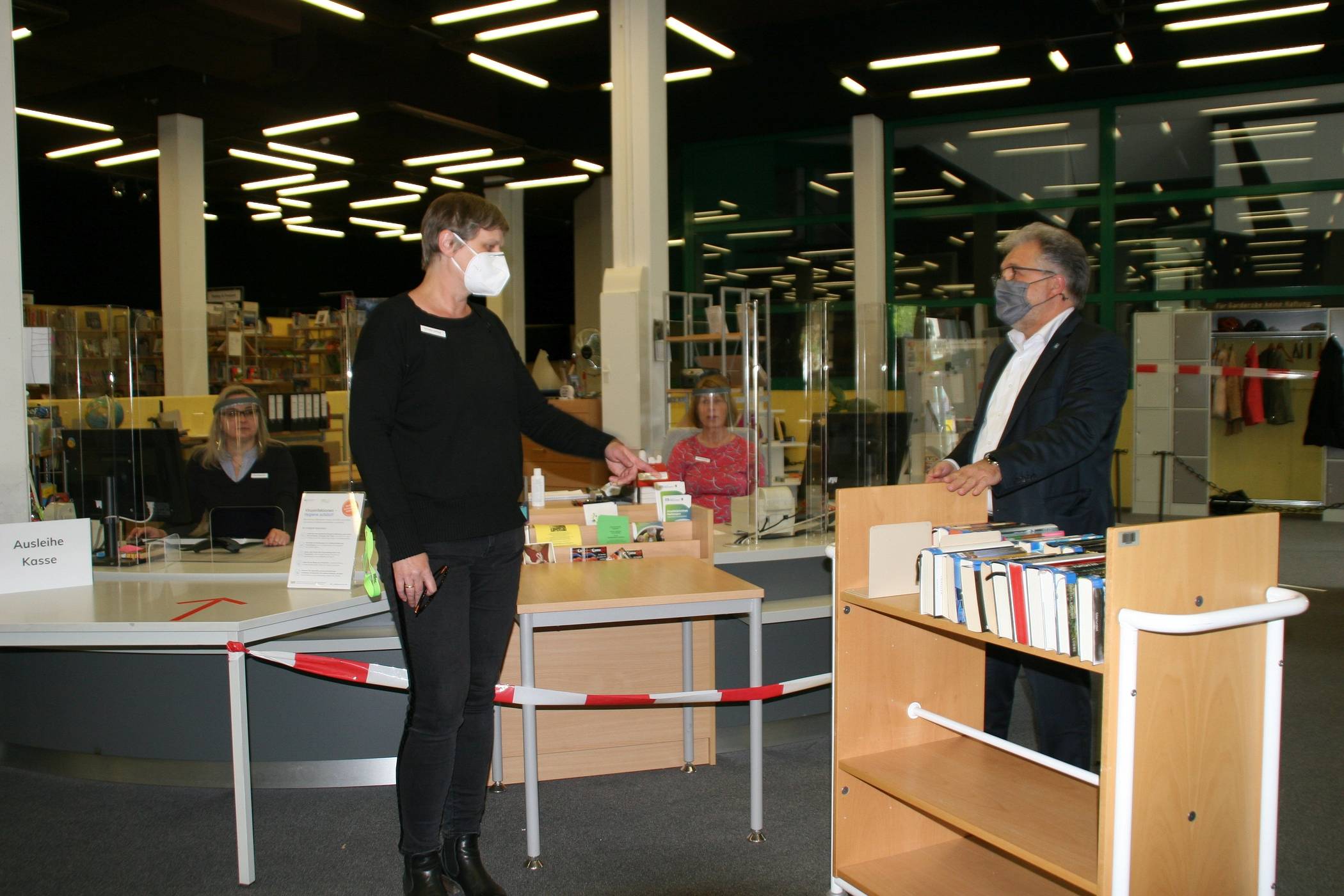  Bürgermeister Thomas Dinkelmann im Gespräch mit Bibliotheksleiterin Ursula Leifeld. Im Hintergrund bereiten sich die Mitarbeiterinnen Iryna Ostapenko (l.) und Petra Kampf auf den ersten Ansturm auf die Bibliothek. vor. 