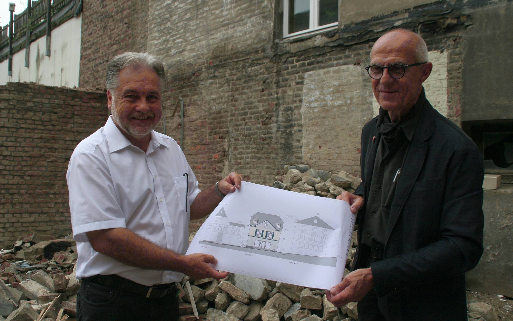  Bürgermeister Thomas Dinkelmann und Architekt Karl J. Stamm mit einer Zeichnung, auf der die Vorderansicht des Hauses Oberstraße 7 zu sehen ist.  