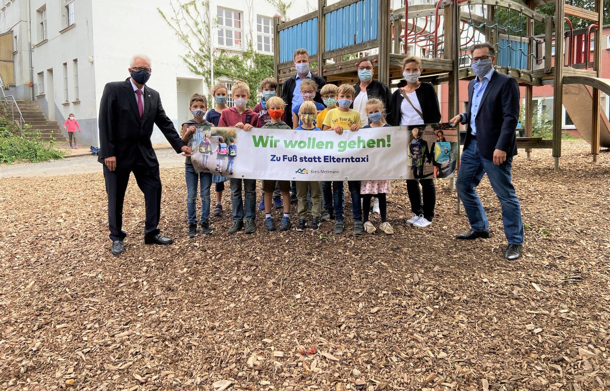  Landrat Thomas Hendele, Marcus Weikämper, Schulleiter der Gemeinschaftsgrundschule Gruiten, Schulamtsdirektorin Andrea Terwint, die Haaner Bürgermeisterin Dr. Bettina Warnecke und Sascha Becker, Leiter Verkehrssicherheit Kreis Mettmann (v.l.), halten gemeinsam mit den Grundschülern das Banner. 