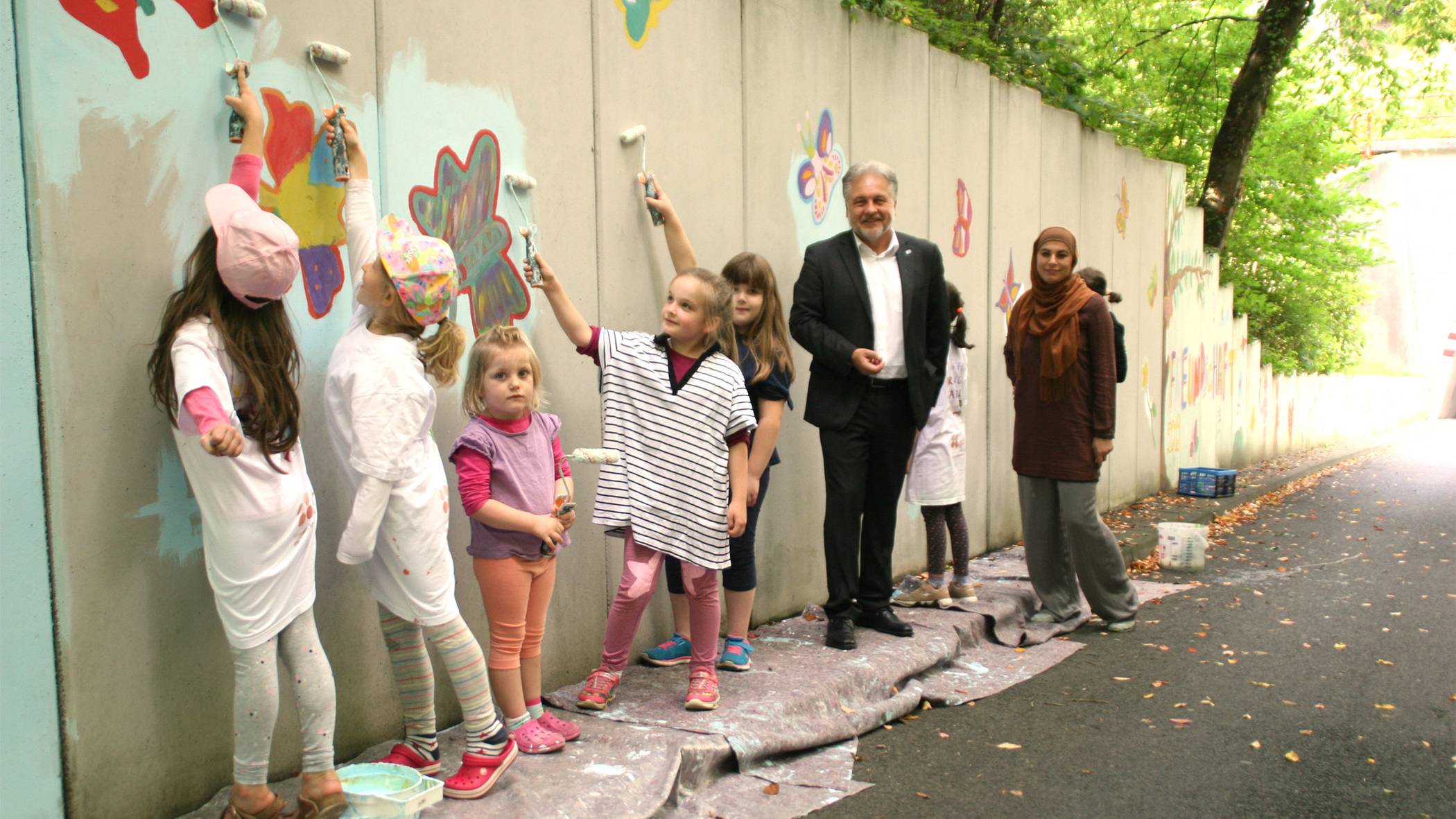  Tamara Tabaković-Halilović vom IKZ und Bürgermeister Thomas Dinkelmann mit zahlreichen Kindern bei der Malaktion am Brücker Berg. 