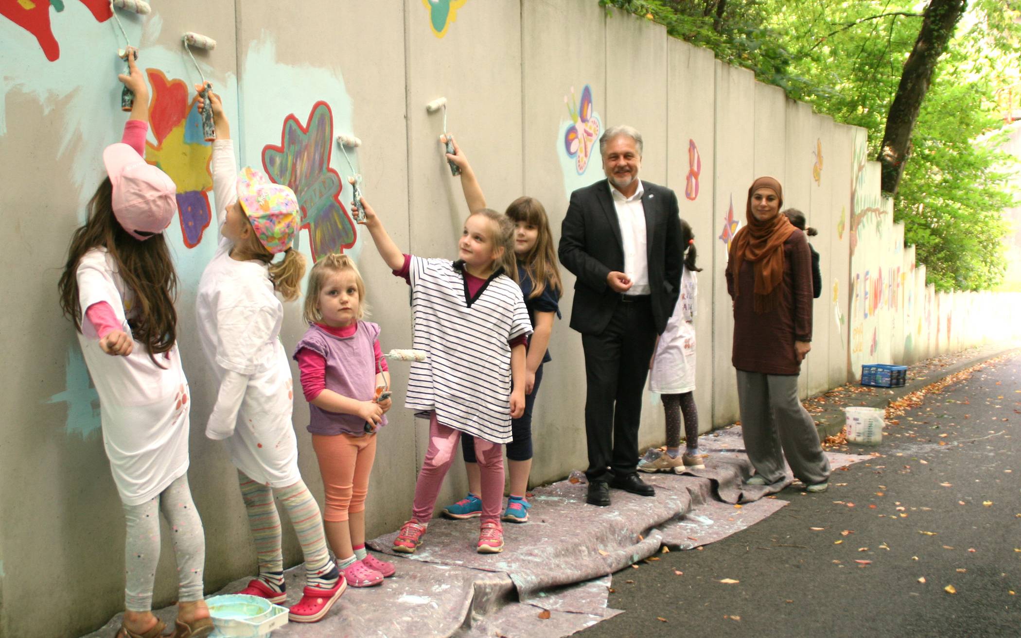  Tamara Tabaković-Halilović vom IKZ und Bürgermeister Thomas Dinkelmann mit zahlreichen Kindern bei der Malaktion am Brücker Berg. 