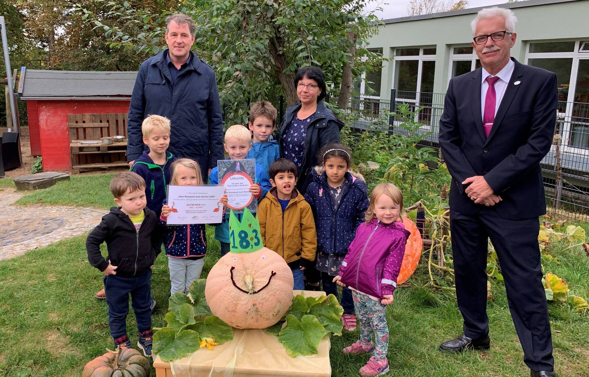  (v.l):  Dirk Sondermann, Geschäftsführer KDM, Ulrike Leineweber, Leiterin der Städtischen Kita Rheinstraße und Thomas Hendele, Landrat Kreis Mettmann, mit den Kindern und dem Siegerkürbis. 